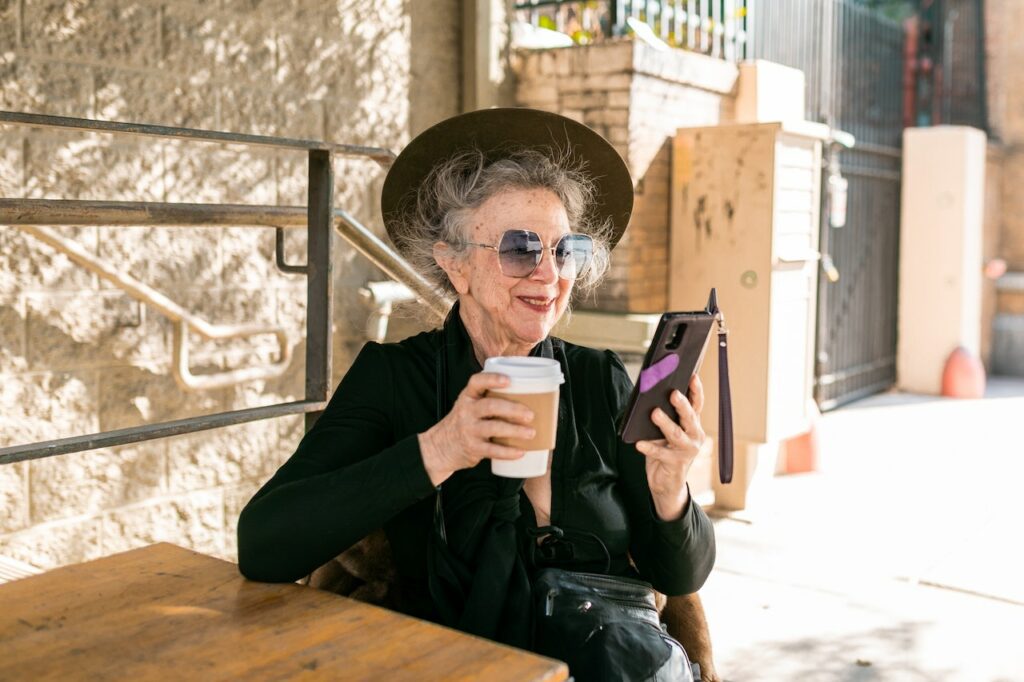 Relaxed senior woman studying a passive income on her phone