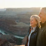 A happy retired couple looking out over a beautiful scenic vista during sunset.